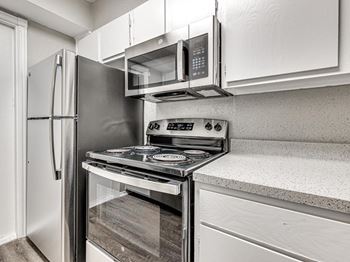 A kitchen with stainless steel appliances and white cabinets
